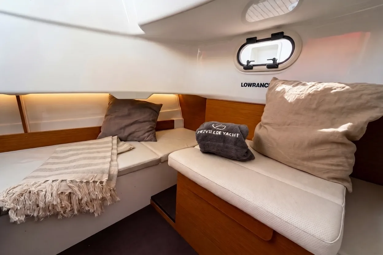 Camarote interior del Jeanneau Cap Camarat 8.5 CC de Rumbo Salou, con cojines y ojo de buey